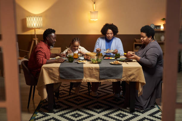 istock Big Black Family Sitting at Dinner Table Together 2081375895