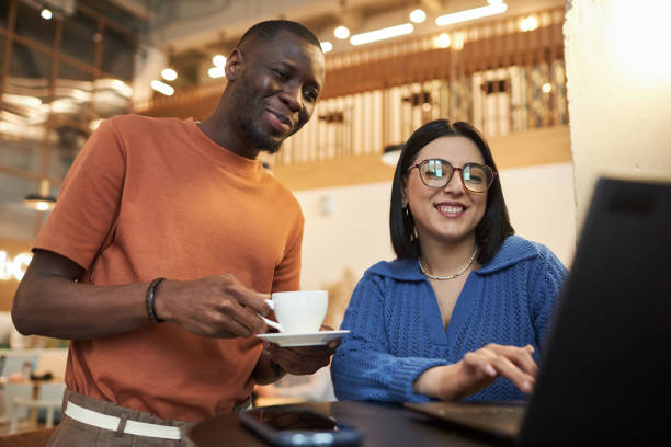 istock Two Smiling People Looking at Laptop Screen in Coffee Shop 2081387857