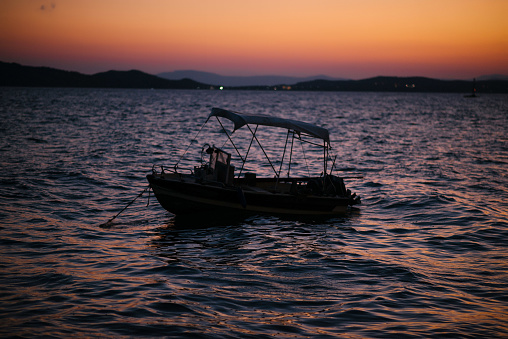 Sunset on the sea with boat in Ouranoupolis city. Halkidiki, Greece