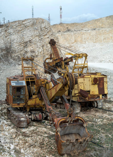 Old rusty yellow equipment in limestone quarry in Europe