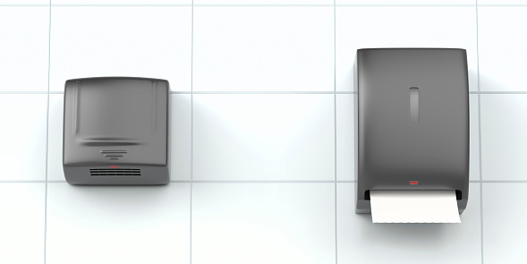 Black automatic paper towel dispenser and electric hand dryer in public toilet