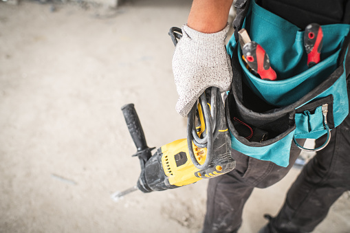 Worker using hammer drill at a construction site