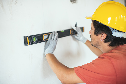 Construction worker using leveling tool during interior decoration/reconstruction