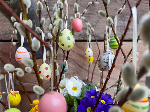 easter eggs, beautiful easter decoration with colorful eggs and fresh spring flowers with selective focus at garden in April. Easter holiday concept background