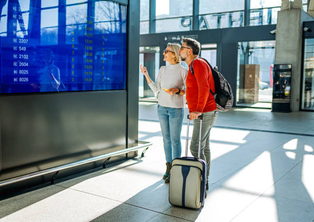 istock Couple looking at the information board at a train station 2081470736