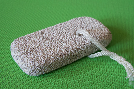 Rectangular block made of natural pumice stone for foot skin care.