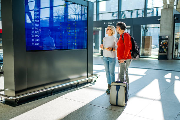 istock Couple looking at the information board at a train station 2081480435