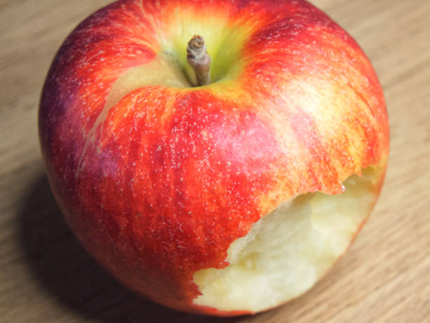 istock Big bitten apple on a wooden background. Ripe red apple. 2081482121