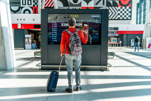 istock Man holding passport in front of information board 2081482662