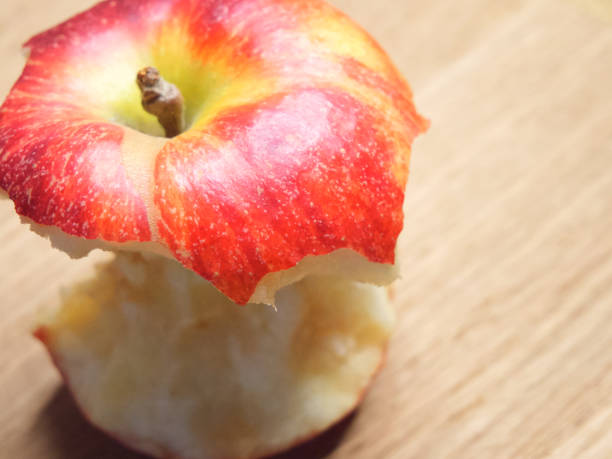 istock Red apple core on a wooden background. A bitten apple close-up. 2081482671