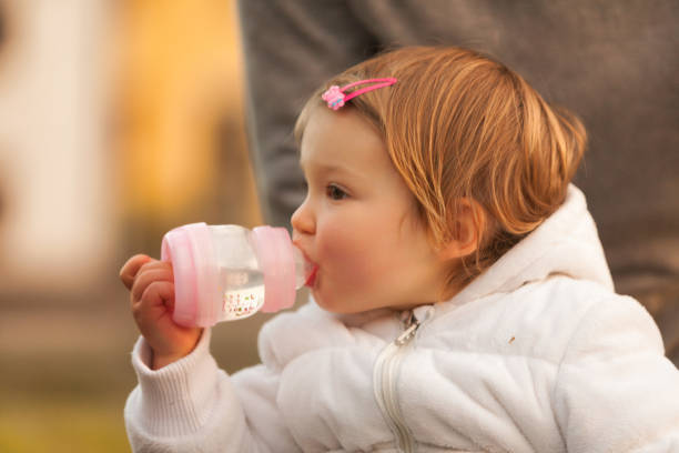 With a gentle grasp, the young one quenches her thirst, peaceful and serene