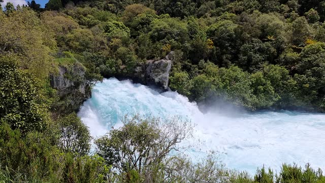 slow motion side view of the amazing Hula Falls flowing surrounded by the beautiful native bush in New Zealand