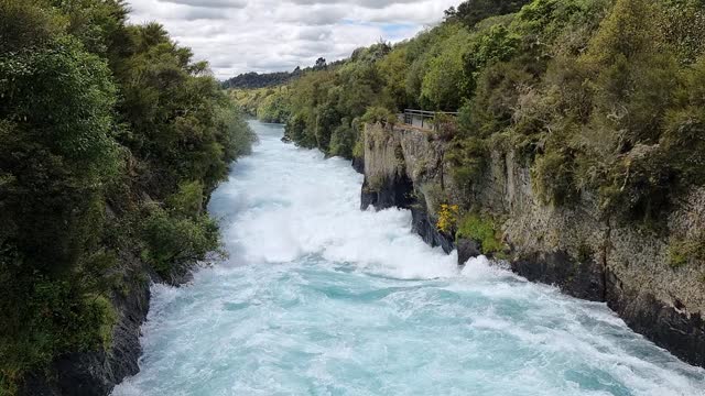 slow motion of the spectacular Huka Falls flowing down the canyon surrounded by native bush in New Zealand