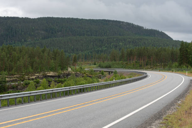 istock highway with a sharp bend in Norway that leads into a mountain tunnel 2081502176