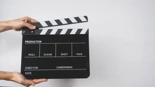 Photo of Clapper board or movie slate with hands use in video production , movie, cinema industry.