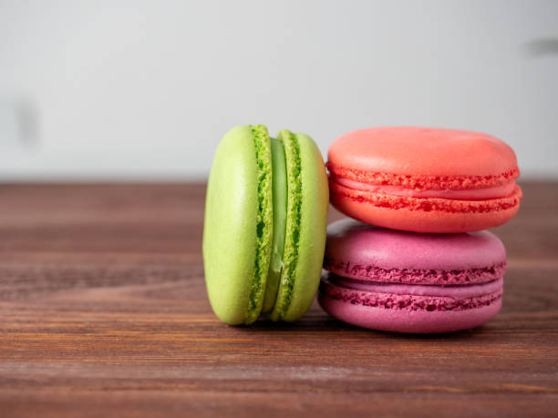 istock three macaroons on a wooden background. The back has a light blurred background. Side view. Delicious sweet dessert 2081559249