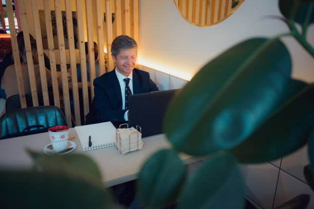 istock Man in suit sitting at table with laptop 2081617206