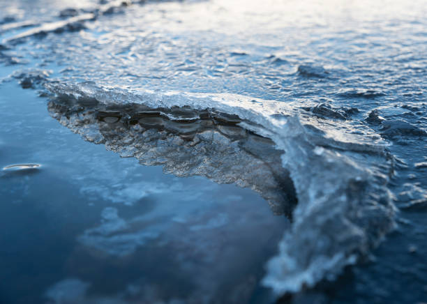 A layer of ice protruding from the water