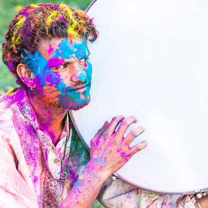 Portrait of a young man covered in colored dye while celebrating the festival of Holi in Jaipur, India.