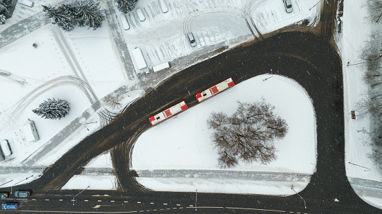 Drone photography of a bus stop in a city with couple of buses during winter stormy day