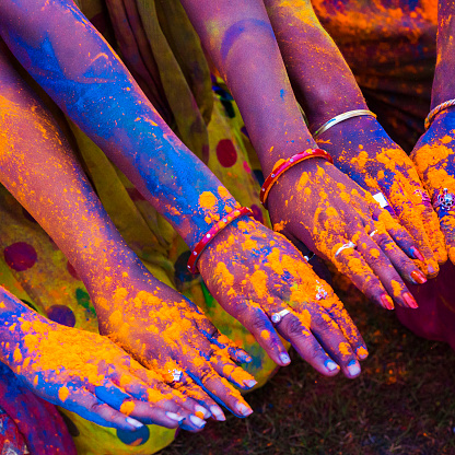 Group of friends showing the colored dye on their hands while celebrating the festival of Holi in Jaipur, India.