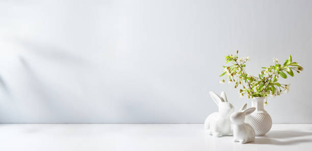 istock Spring flowers in a vase and easter bunny on a white table. Easter background with copy space 2081693234