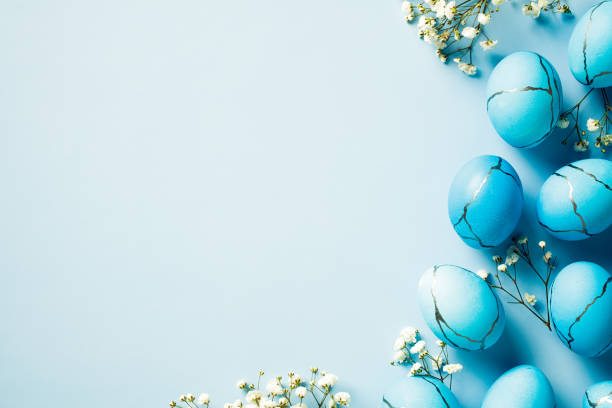 istock Blue marble Easter eggs with flowers on pastel blue background 2081695877