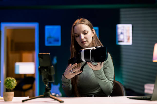 istock Young entertainer recording with mobile phone, presenting VR headset to viewers 2081698480