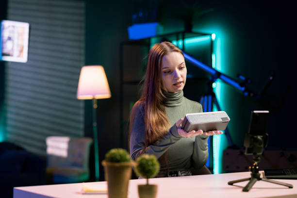 istock Young entertainer in neon lit studio doing technology review of portable speaker 2081701056