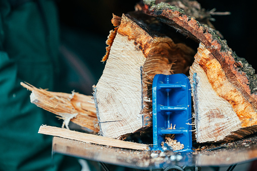 Close-up of a log splitter splitting a large block of wood