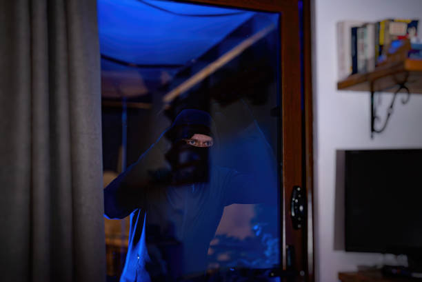istock The thief looks through the glass inside the house. 2081719207