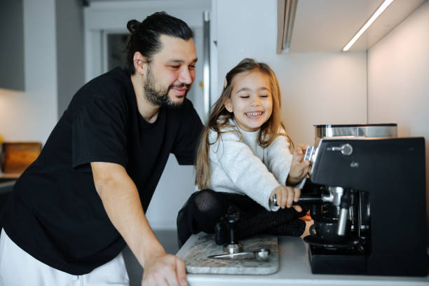 istock Little girl coffee time bonding with dad helping daddy making coffee at home 2081725006
