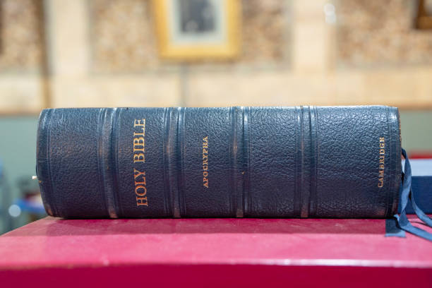 antyczna oprawiona w skórę biblia z apokryfami na czerwonej powierzchni - credo zdjęcia i obrazy z banku zdjęć