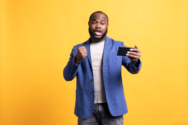 istock Energetic man shouting, playing videogames on smartphone, celebrating 2081768168