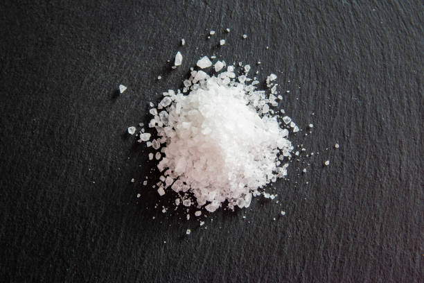 istock White salt cristals for food on the black background. 2081773516