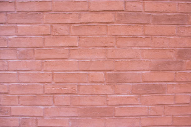 Structural stone wall of the modern building consists of red little bricks. Nature structural background.