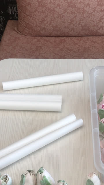 The woman cuts the paper with scissors. For packing homemade marshmallows. Nearby on the table tulips from Zephyr. Vertical video.