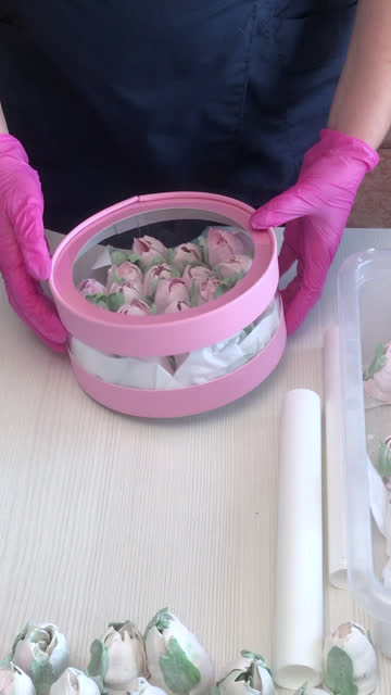A woman demonstrates a box with a homemade marshmallow. Closes it with a lid. A pink hatbox. Tulips from marshmallows. Homemade marshmallows. Vertical video.