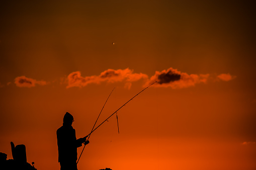 Fisherman Fishing Rod Silhouette at Orange Sunset