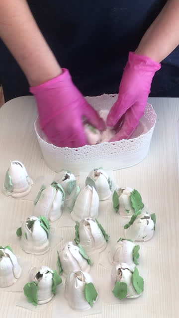 A woman processes marshmallow mesh. Tulips from marshmallows. Homemade marshmallows. Vertical video.