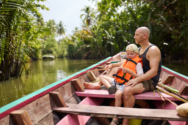 istock A father sits with his son on a longtail boat during a trip on a canal 2081812962