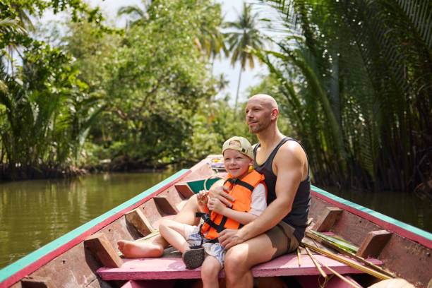 istock A father sits with his son on a longtail boat during a trip on a canal 2081814012