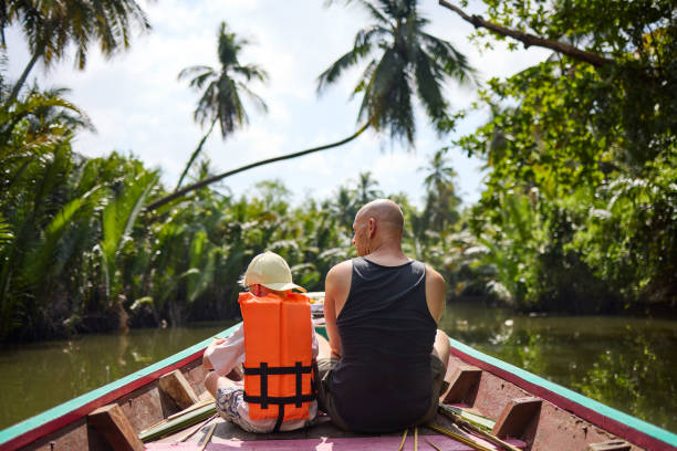 istock A father sits with his son on a longtail boat during a trip on a canal 2081814575
