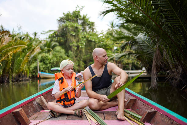 istock A father sits with his son on a longtail boat during a trip on a canal 2081815634