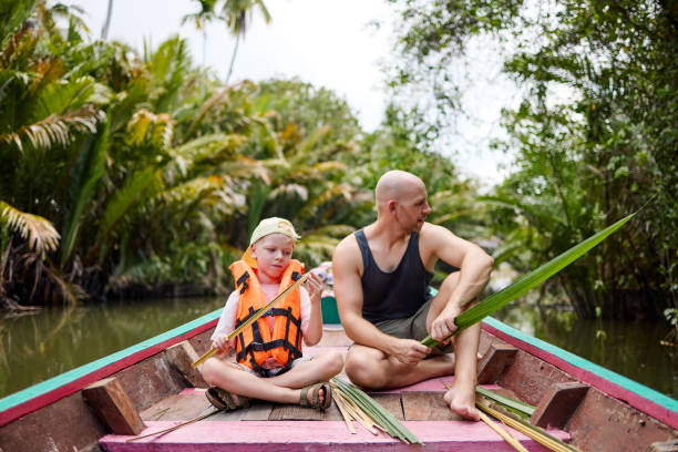 istock A father sits with his son on a longtail boat during a trip on a canal 2081816695