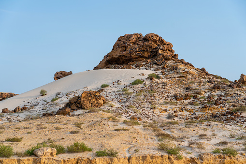 Low sandstone hill with white sand in Wahiba desert in Oman at sunset.