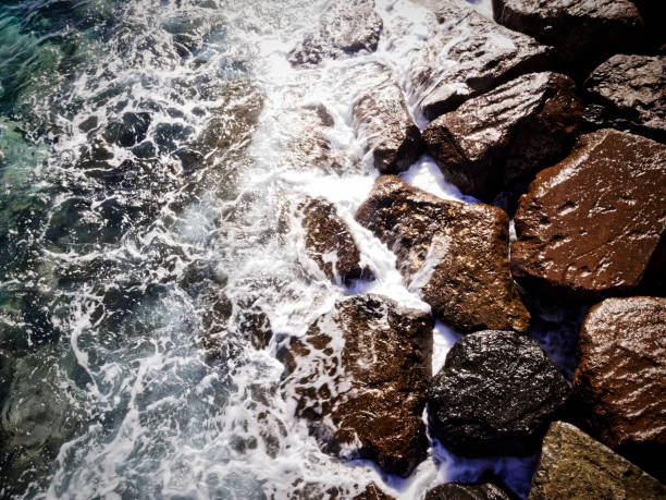 Rocky beach with waves crashing in and scattered rocks in the ocean