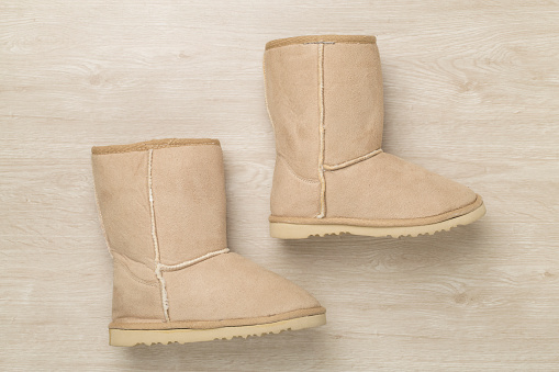 Suede boots on wooden background,top view