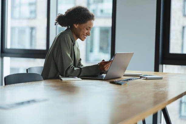istock A woman sits at a table using a laptop computer in a building interior 2081921973