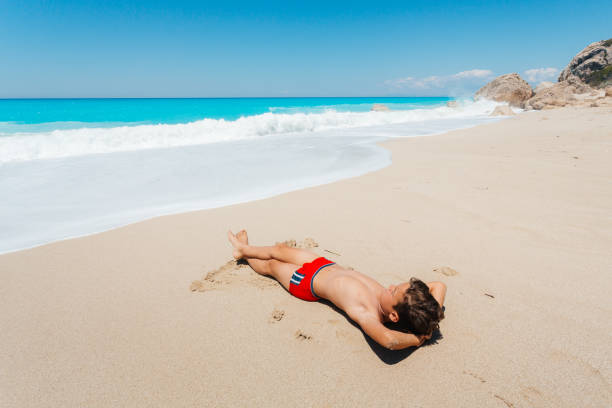istock Boy enjoys sunbathing on the beach 2081930165